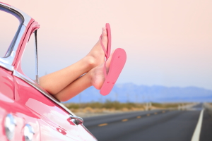 Freedom car travel concept - woman relaxing with feet out of win